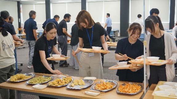 納涼祭で料理を受け取る社員たち